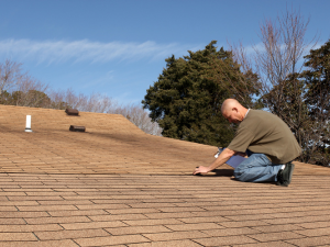 A professional roofing contractor in Livermore inspecting roof damage after a storm.