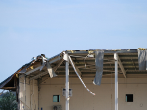 Damaged commercial roofing in Danville from wind and blown debris
